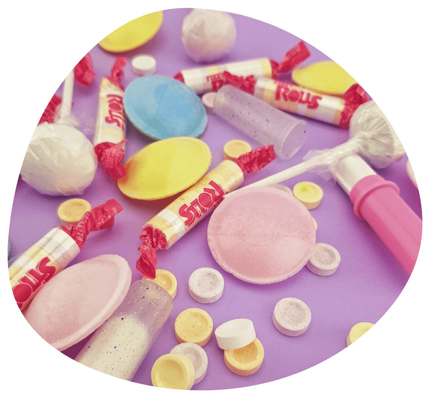 Les bonbons vintages de notre enfance en forme de rouleaux, d'ostilles en pâte à macher et sucettes lolita mise en situation style vintage